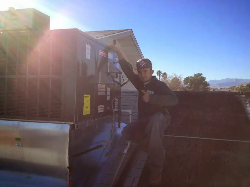 HVAC technician performing AC Tune-Up on a rooftop unit in Otsego